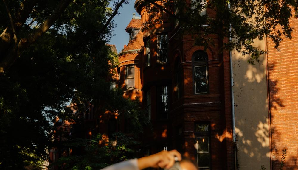 A woman takes a snapshot as she walks a residential neighborhood.