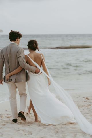 Bride and groom walking on the beach