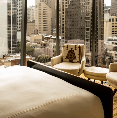 A chair against the floor to ceiling windows in a room at Viceroy Chicago