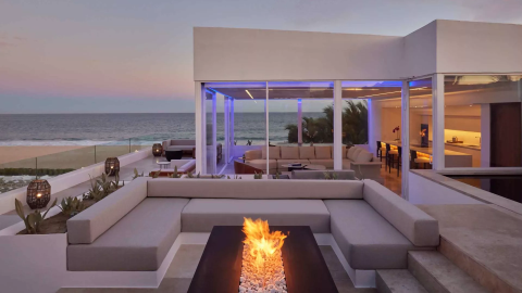 Exterior of a villas with a view of the ocean and a patio fireplace