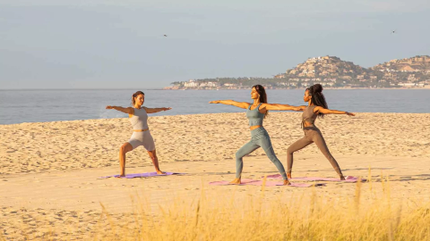 3 women doing yoga on the beach at Viceroy Los Cabos