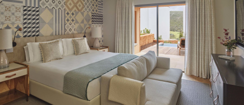A king bed ina room with a couch, dresser, and a patio at Ombria Algarve