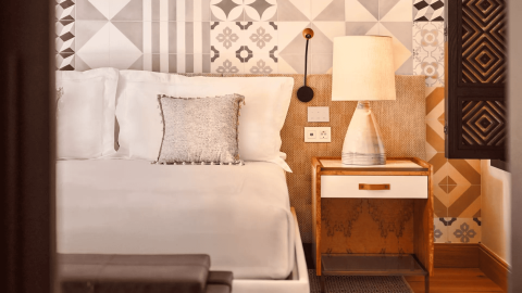 A queen bed and a side table with a lamp at Ombria Algarve