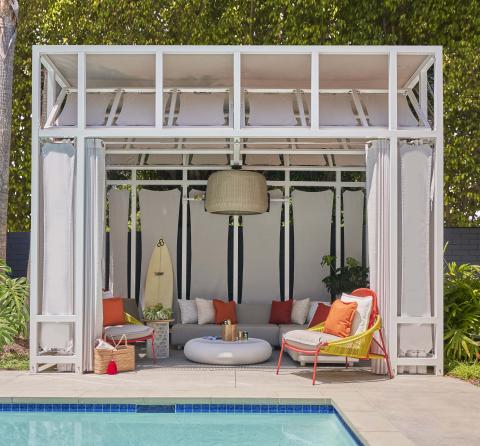 A cabana with a long couch and lounger chairs near the pool at Viceroy Santa Monica