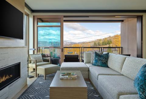 A room with an L-shaped couch and a fireplace at Viceroy Snowmass