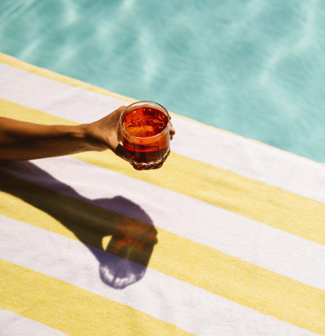 An arm holding a cocktail poolside at Viceroy Washington