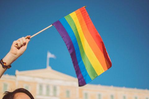 A person waving a pride flag at the pride parade near Viceroy Zena Washington DC