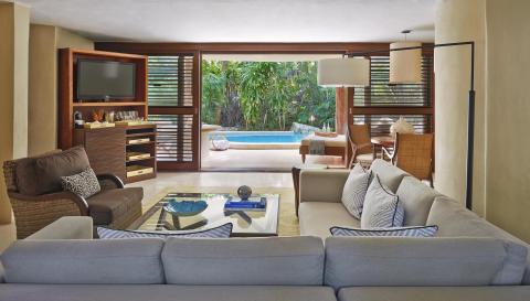 The living space with couches and chairs and a patio with a private pool at Viceroy Riviera Maya