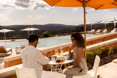 A couple enjoying a lunch on a sunny patio