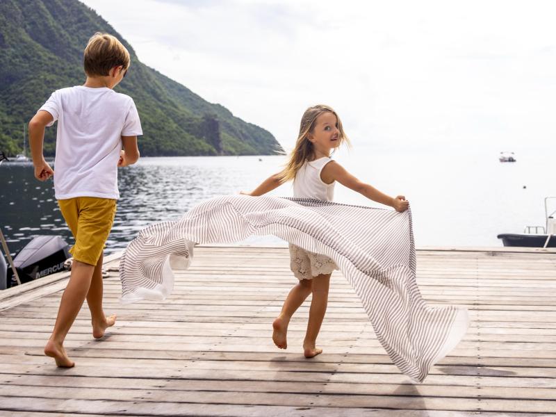 kids running on dock toward ocean
