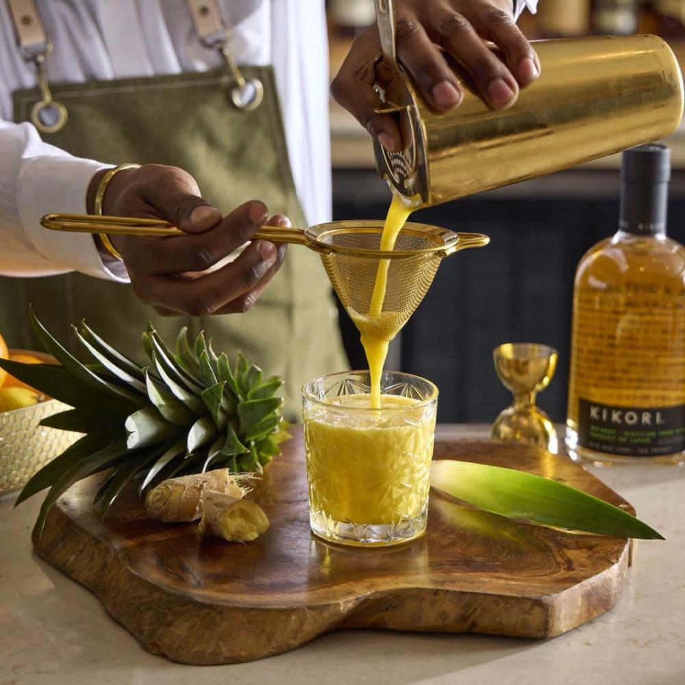 A bartender at Pandan strains a fruit juice to make a Red Panda cocktail