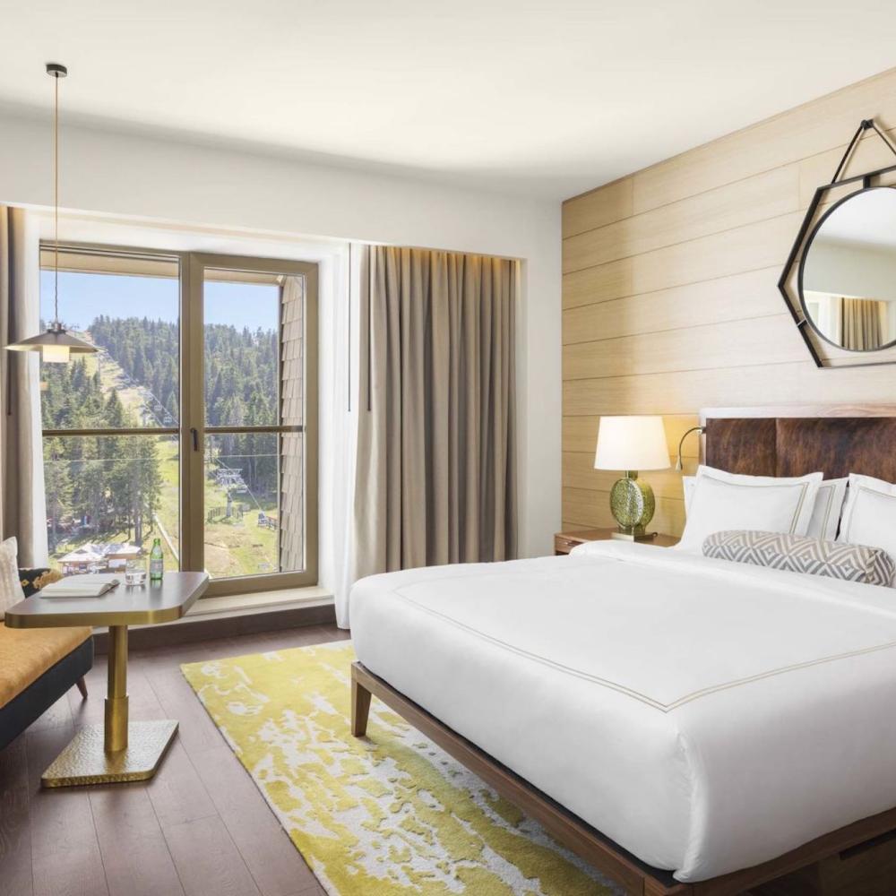 King room with a king bed, couch, dresser and tv at Viceroy Kopaonik Serbia