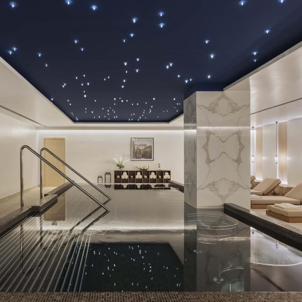 The spa at Viceroy Kopaonik Serbia, with a wading pool and recliners under a ceiling painted like a starry sky
