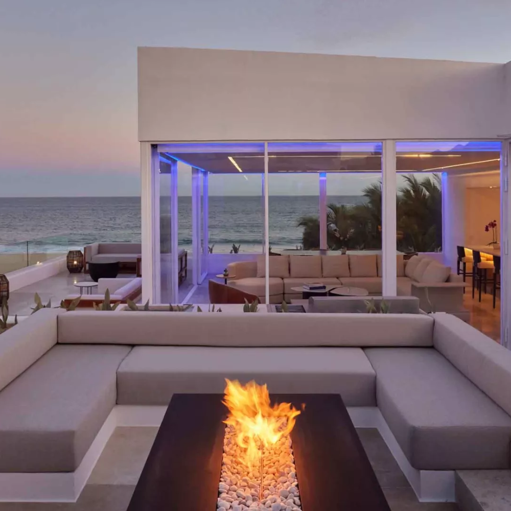 Exterior of a villas with a view of the ocean and a patio fireplace