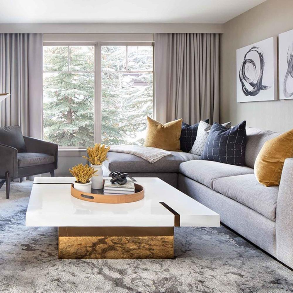 A ampla sala de estar com uma mesa de centro em mármore branco, um sofá e uma televisão no Viceroy Snowmass
