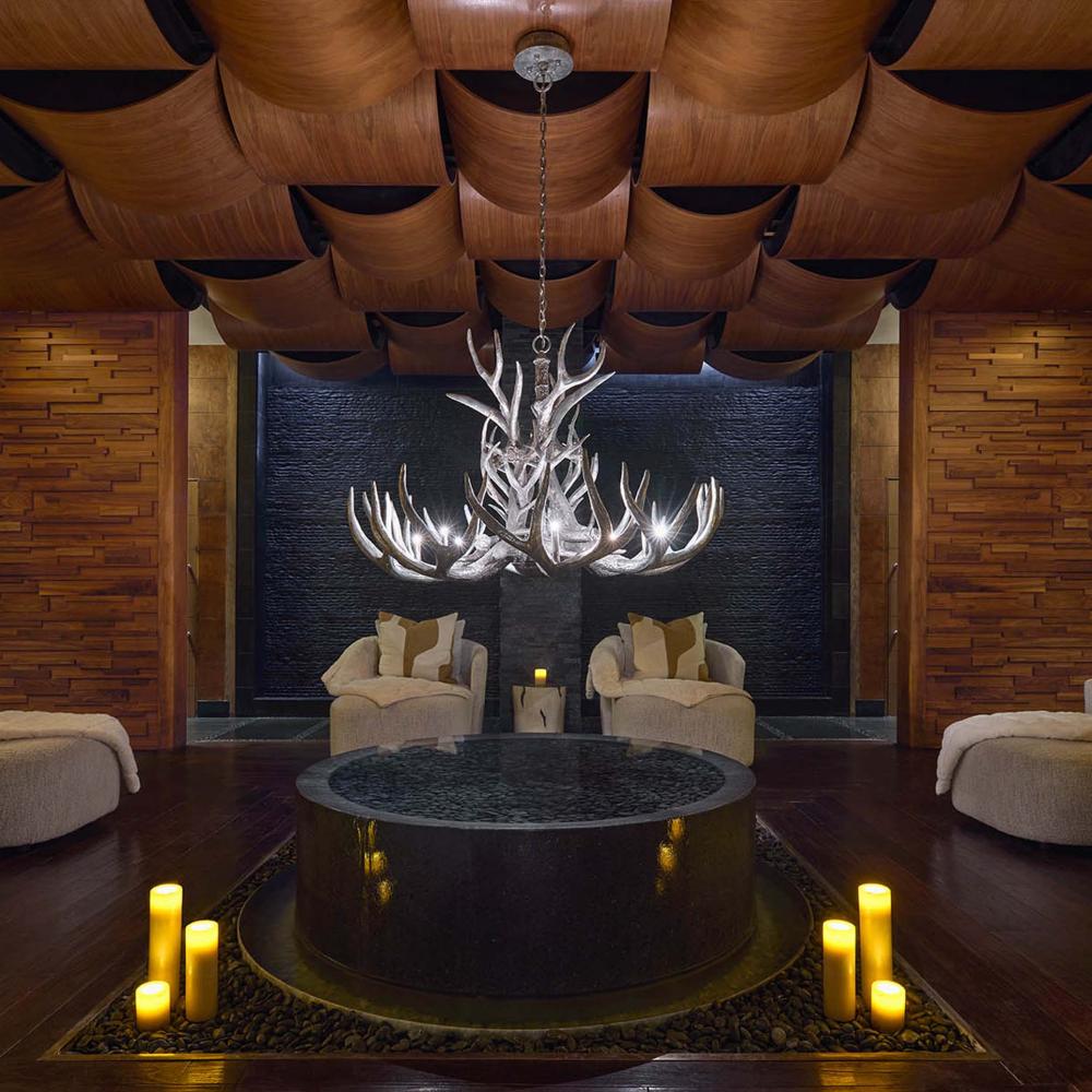A Viceroy Snowmass spa waiting room, featuring cozy chairs and plush curtains, lit by candle