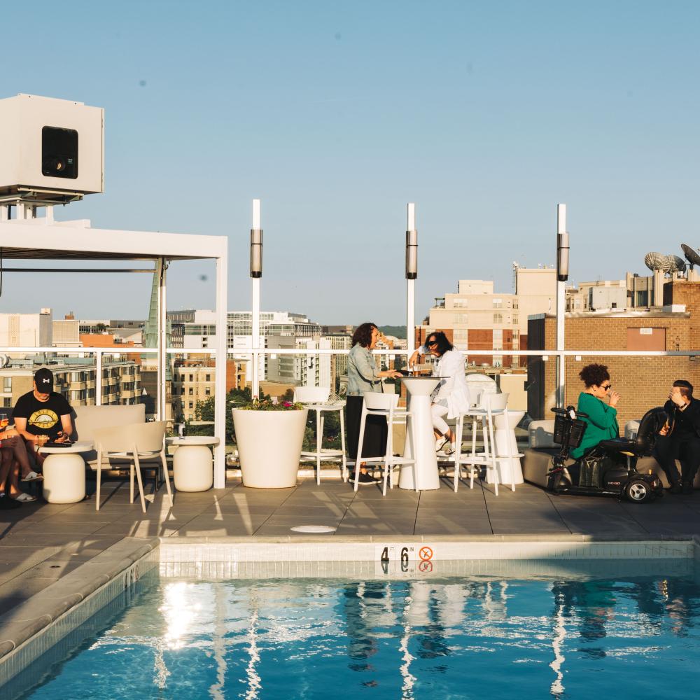 rooftop pool surrounded by tables of people