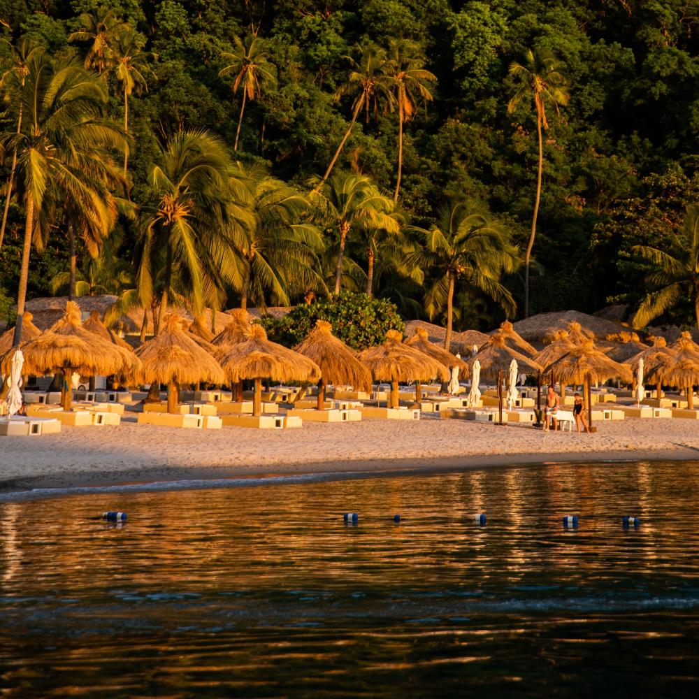 Sun shades line white sand beaches at Viceroy Sugar Beach.
