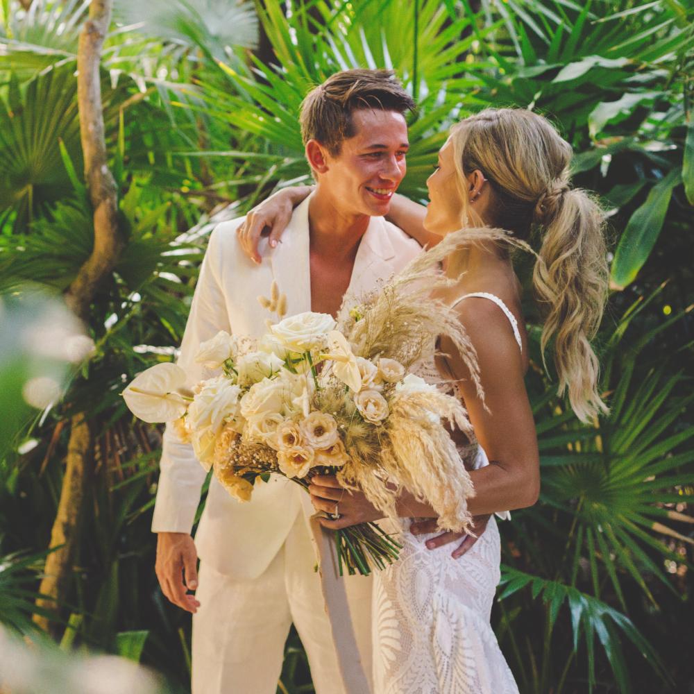 A couple happily smiling at each other in a beautiful tropical resort