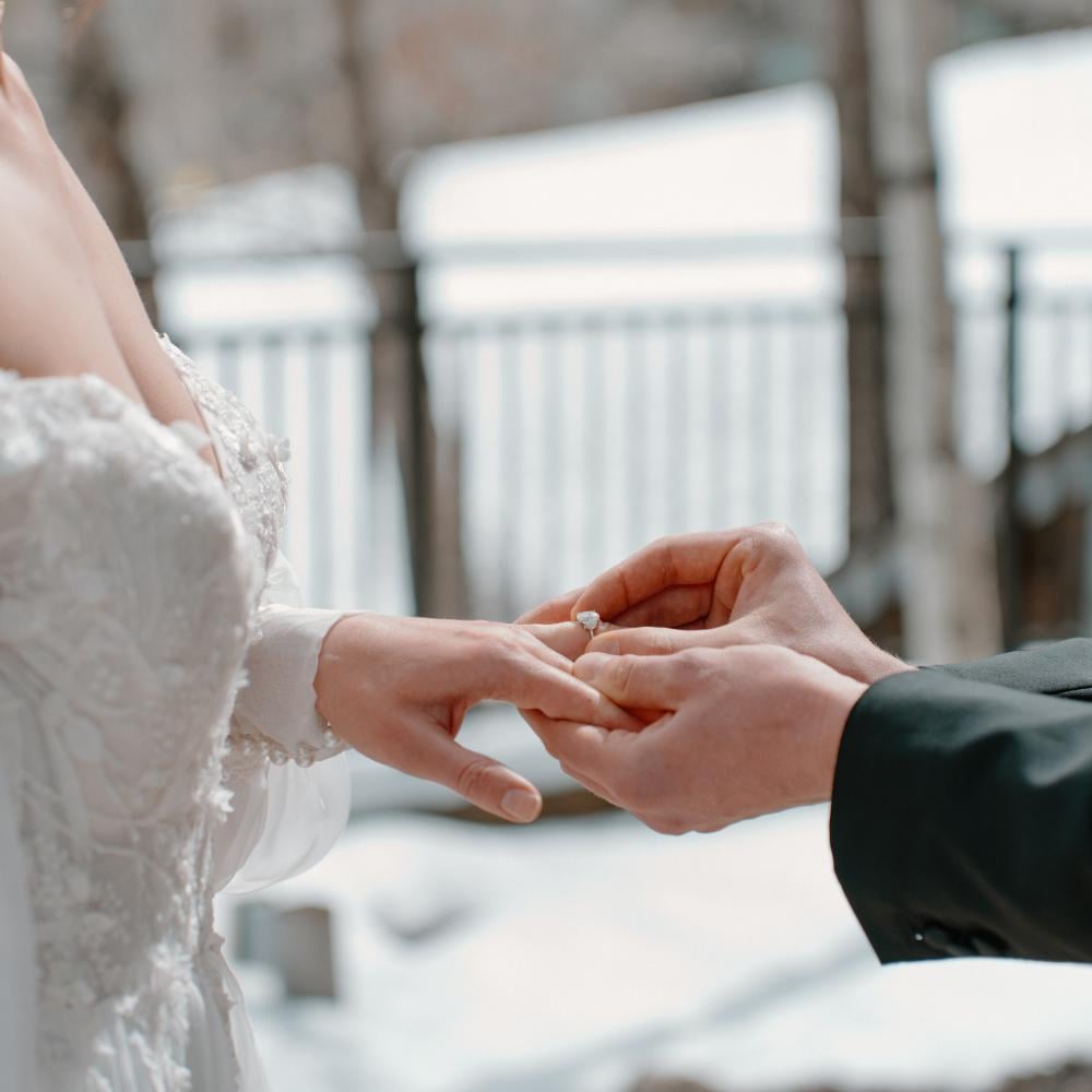 A groom putting on a ring on the brides finger