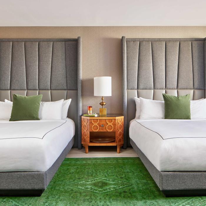Bedroom with two queen beds and a large green carpet