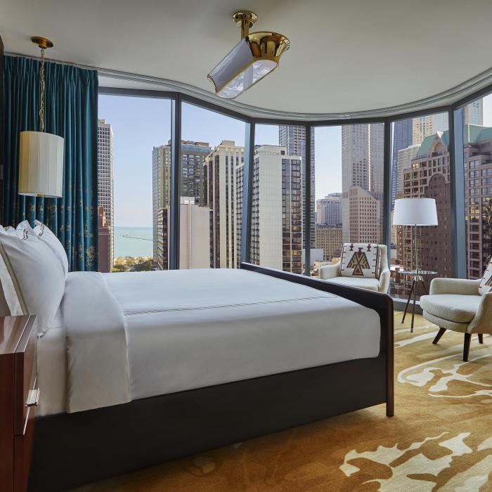 A suite at Viceroy Chicago with a panoramic bay window looking out on the Chicago skyline
