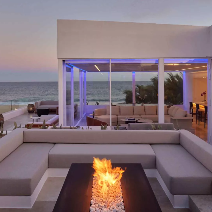 Exterior of a villas with a view of the ocean and a patio fireplace