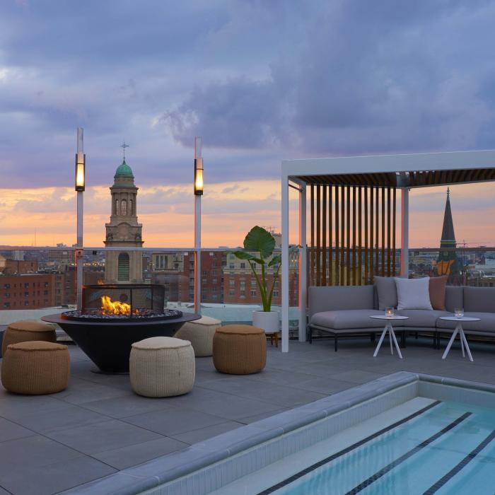 A rooftop pool with a fire pit and cabanas at Viceroy Zena Washington