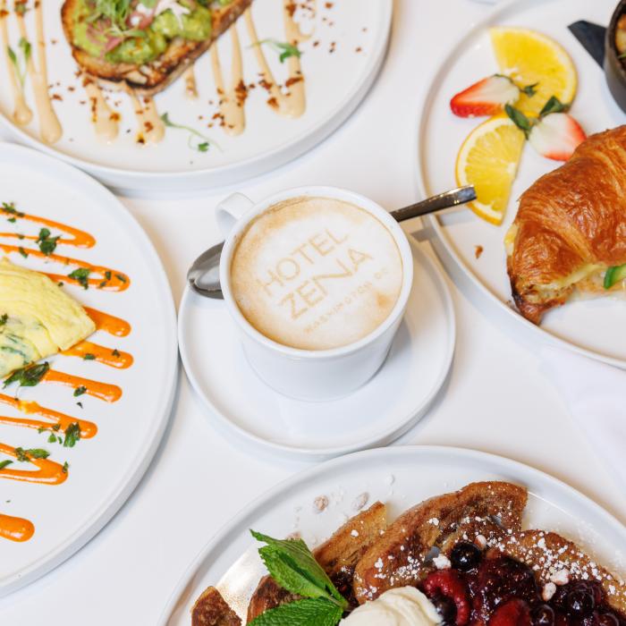Brunch items from Figleaf, arranged on a table: Vanilla French Toast, Omelette, Avocado Toast, Croissant sandwich, and a latte.