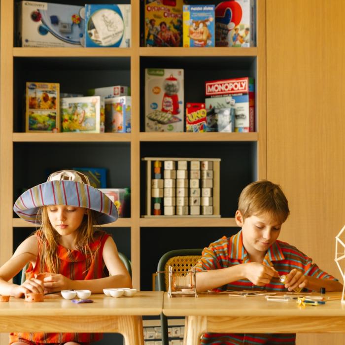 Dos niños están sentados pintando en el club infantil.