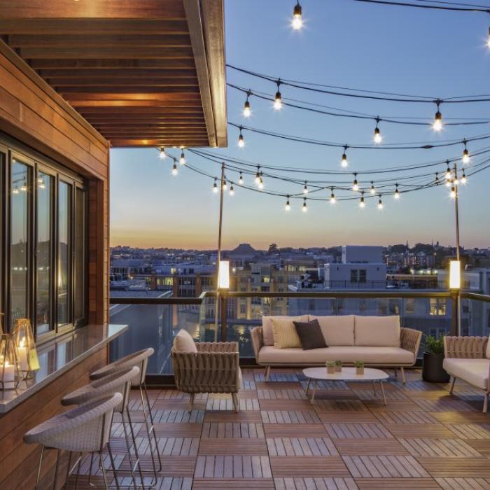 Hush, the rooftop patio bar at Viceroy Washington DC, at dusk. String lights illuminate the wood-panelled decor