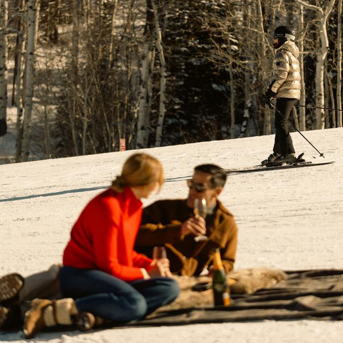 Couple sitting on a mountain slope having a picnic.