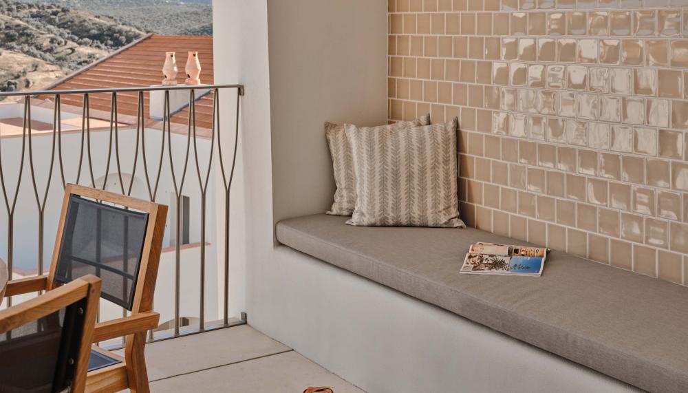 Balcony with long bench and dining area