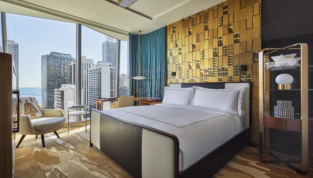 A room with floor to ceiling windows, a queen bed, and desk at Viceroy Chicago