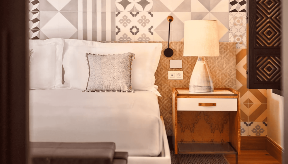 A queen bed and a side table with a lamp at Ombria Algarve