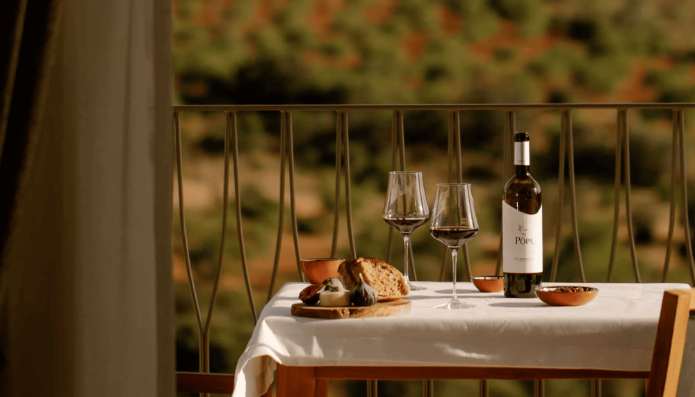 A table with a wine bottle , cheese and bread at Ombria Algarve