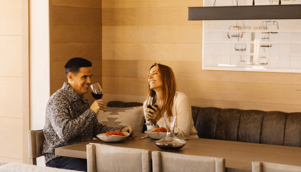 A couple laughing, eating and drinking wine at Viceroy Snowmass