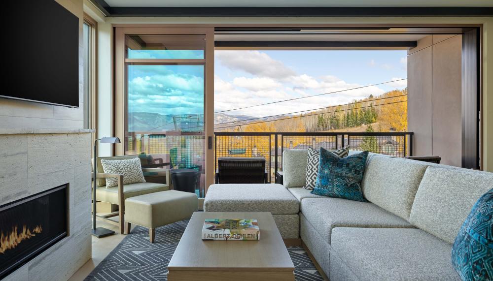A room with an L-shaped couch and a fireplace at Viceroy Snowmass