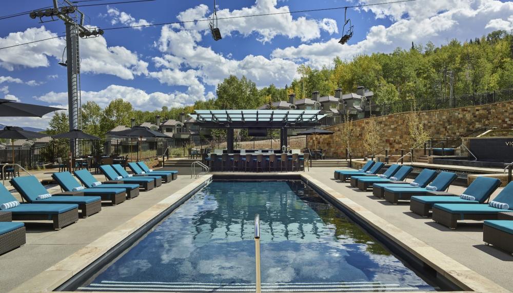 viceroy snomass pool with pool deck, and chairs