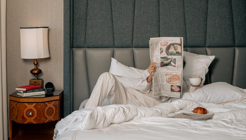 Guestroom with guest reading the newspaper