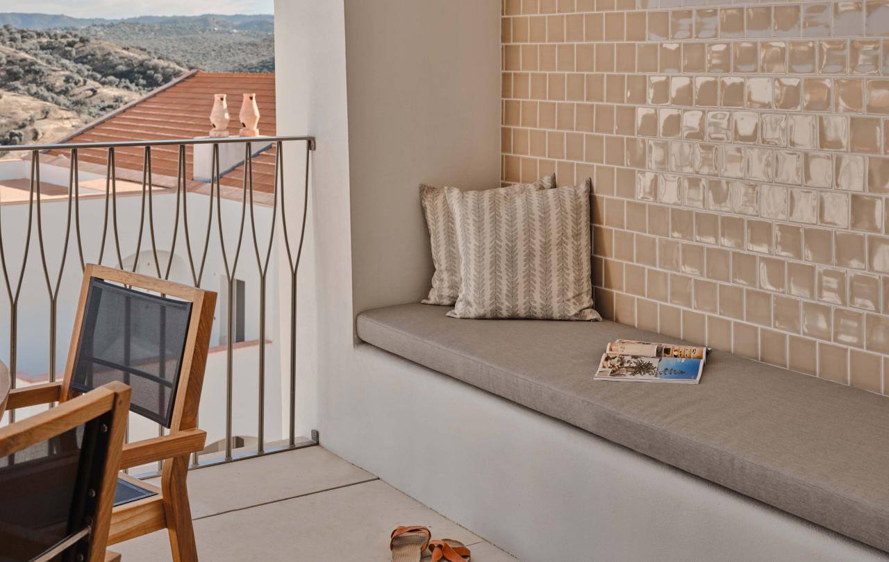 Balcony with long bench and dining area