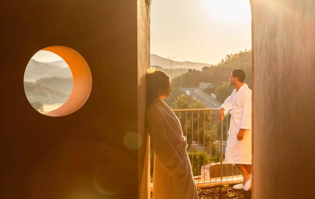 two people stand in white robes on balcony