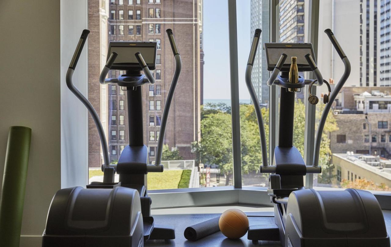 Two exercise bikes in the Viceroy Chicago fitness centre, by a window overlooking the Gold Coast neighborhood of Chicago