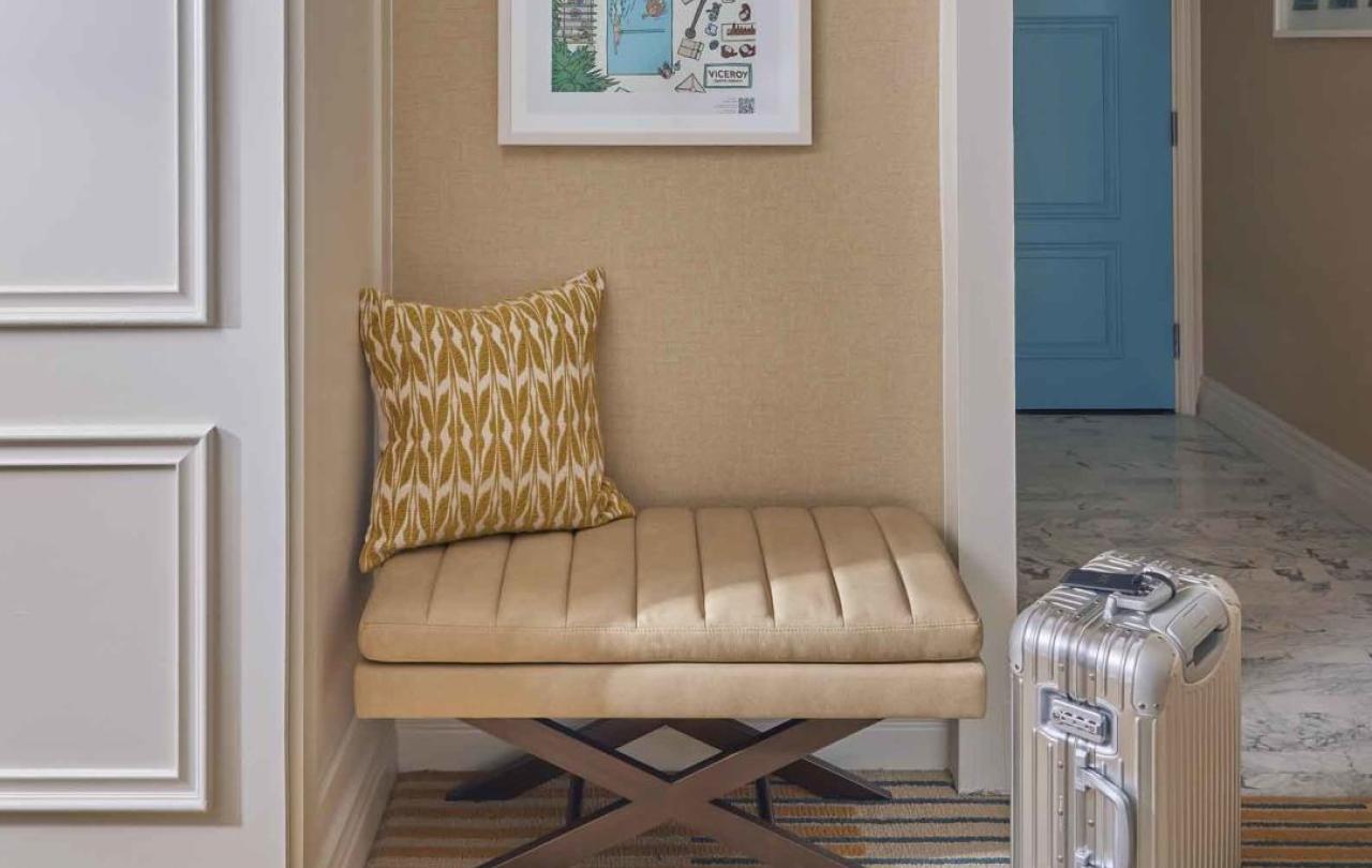 A comfy looking stool with guest luggage in front
