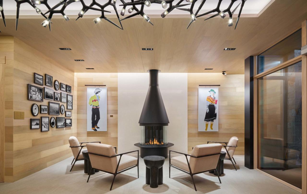 Two chairs face inward towards a indoor fireplace