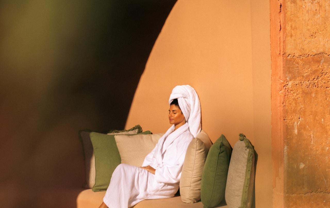 Um hóspede descansa tranquilamente num recanto com um banco embutido, emoldurado por um grande arco.