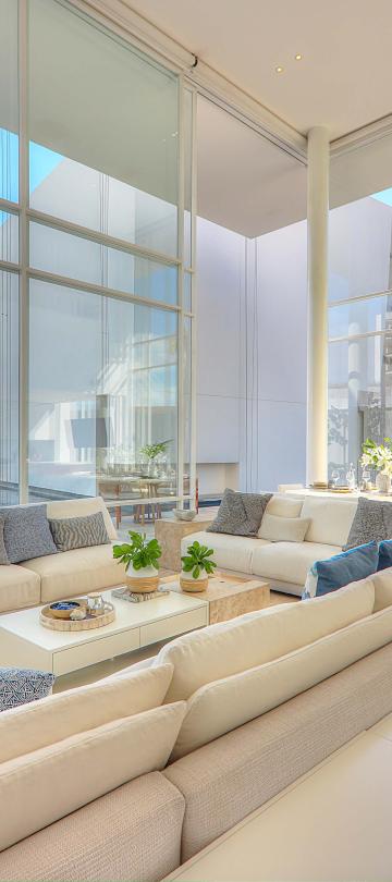 los cabos waterside villa living space with a large sofa and floor to ceiling windos=ws