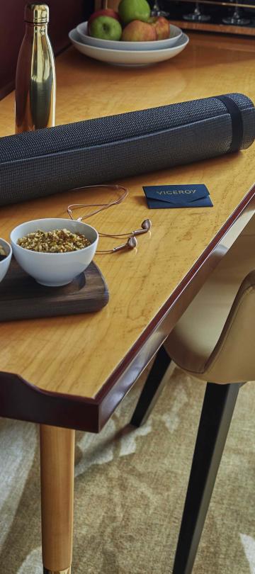 bowls of snacks and personal items on desk and chair inside Superior Room at Viceroy Chicago