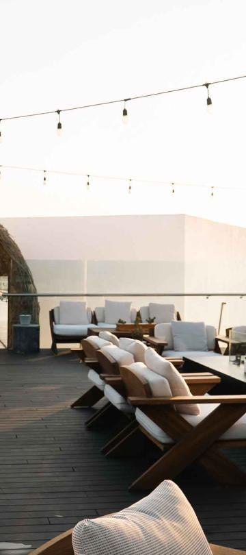 exterior deck with seating, lighting, and archway