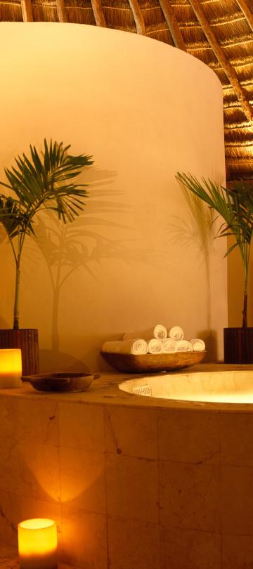 pool surrounded by candles and palm leaves